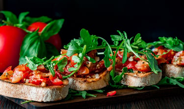 Frische Tomaten-Basilikum-Bruschetta auf geröstetem Baguette mit Rucola.