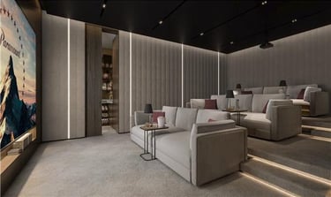 Luxury home theater with plush gray sofa seating, tiered rows, and a large projection screen.