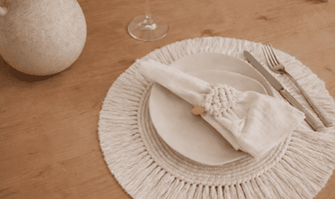 mesa bohemia con mantel circular, y portaservilletas tejido a mano