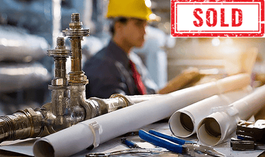 Plumber working at a desk with pipes and tools, labeled "SOLD".