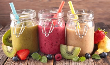 three jars of fruit smoothies with fruit and strawberries