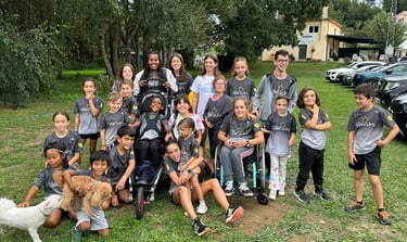 Grupo numeroso de niños y jóvenes, algunos de ellos con diversidad funcional, sonríen para la foto