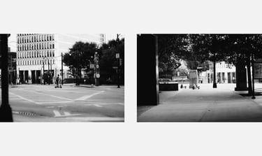 Black and white street photography featuring electric scooters parked on a quiet urban sidewalk.