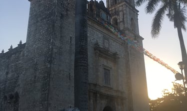 a church with a tall tower with a clock tower in the background
