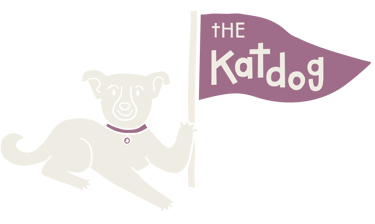 The Katdog Newsletter Logo, a small dog carrying a purple flag