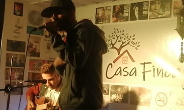 Presentación en vivo con un cantante y un guitarrista acústico en un escenario intimo