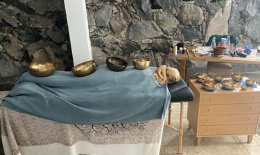 a person laying down covered with sound bowls