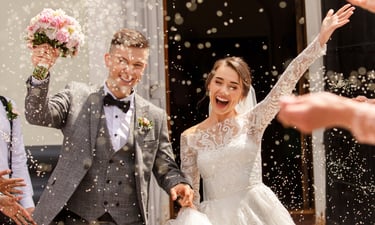 Wedding videographer in Glasgow capturing joyful confetti exit—bride and groom celebrating outside t