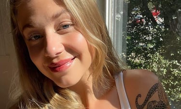 belle blonde de 25 ans avec des tatouages et des lèvres rosées, lip blush