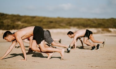 men bear crawling on the beach at a fitness class