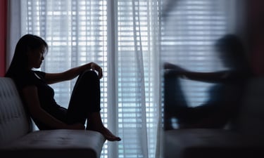 Person sitting alone in silence feeling emotionally isolated, anxious and afraid to speak