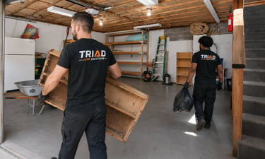 Professional junk removal crew clearing out a garage with old furniture and debris.