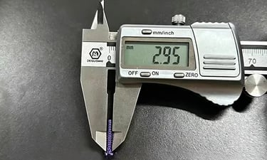 Digital caliper measuring a purple titanium screw showing a 2.95 mm reading on the LCD display | Rui
