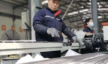 Industrial worker operating cutting or processing equipment in titanium manufacturing workshop for p