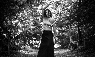 Photo artistique en noir et blanc d'une femme vêtue d'une jupe faisant du cerceau