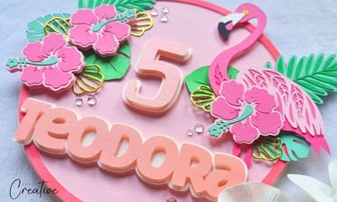 Round cake topper with pink flamingo, flowers, number 5 and a name Teodora on it