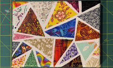 a piece of art work made with colorful triangle fabric scraps