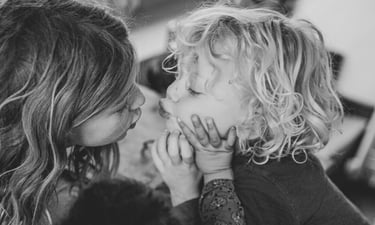 Deux enfants sur le point de se faire un bisous sur les lèvres, par Zohra Elmes