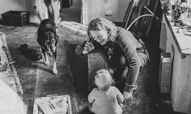 Moment de complicité entre une femme et un bébé pendant qu'un chien regarde l'objectif, Elmes Zohra