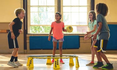 a group of children playing soccer in a gym