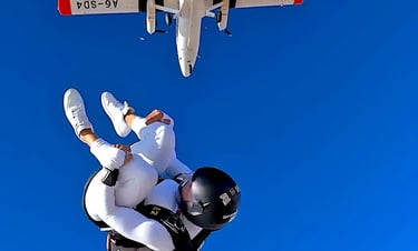 mais alhajri skydiving in white jumpsuit after exiting a plane