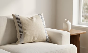 warm neutral color palette living room 2026 navy stripe linen cushion on cream sofa natural light