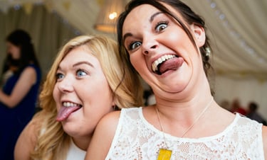 Wedding guests pulling funny faces inside marquee at a South Wales celebration, photographed by Owen Mathias