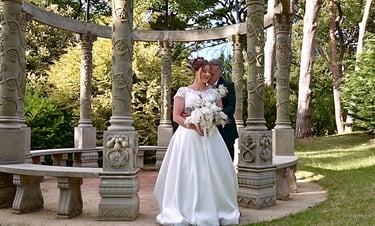 a bride and groom standing posing for a wedding photograph