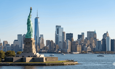 Estátua da Liberdade com skyline de Nova York ao fundo.