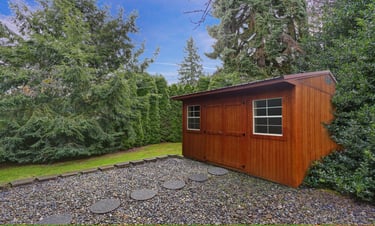 Colonial style shed with lawn and trees