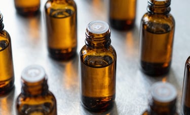 Precise minimalist overhead shot of sealed amber glass bottles on a sterile stainless steel laboratory counter, soft diffused daylight, sharp macro detail