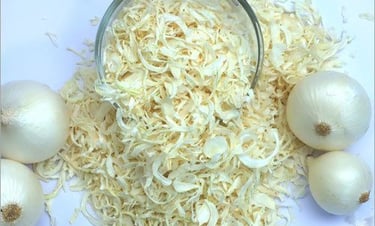 a bowl of dehydrated onions with raw onions on a table