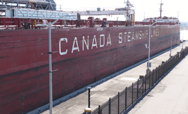 A Large red ship in Lock 3. White lettering says, "CANADA STEAMSHIP LINES".