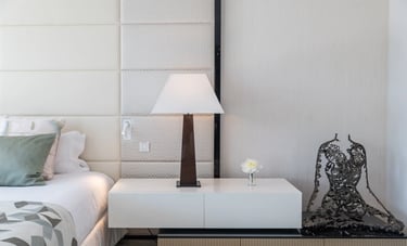Modern bedside table with lamp and sculpture at Villa Serenity