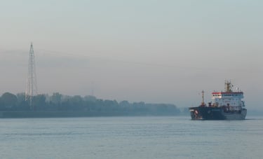 A blue and white tanker ship approaches in the distance.