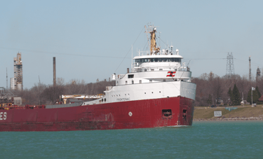 Classic red and white forward pilothouse freighter Frontenac approaching.