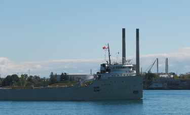 Classic forward pilothouse, tan colored steamship, Alpena passes by 2 smokestacks.