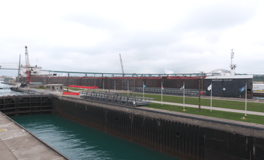 Huge freighter American Century slowly eases into the Poe Lock. MacArthur Lock is in the foreground.