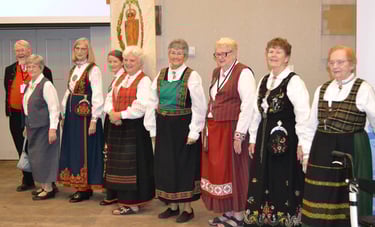 one man and eight women in bunad