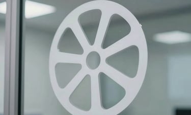 Close-up photography of high-precision white vinyl cutting stickers being applied to a clean glass partition in a professional Indonesian office environment. The design is modern and minimalist with sharp edges.