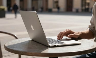 An extremely thin silver ultrabook being used by someone at a contemporary cafe table in a sunny Italian plaza. Focus on the slim profile of the device, high-end lifestyle photography.