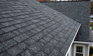 Close-up of a high-quality dark charcoal shingle roof being professionally installed on a residential house in North American / New York City, showing clean lines and expert craftsmanship.