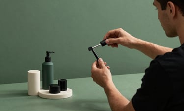 A modern content studio in North America with matte forest green backdrops, where a creative professional is styling a minimalist product shot with elegant props.