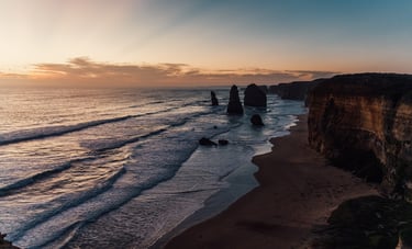 a view of the ocean and cliffs at sunset