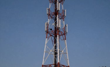 A majestic telecommunications tower standing tall against a clear twilight sky in a South American landscape, illuminated by subtle ground lights, sharp and professional style.