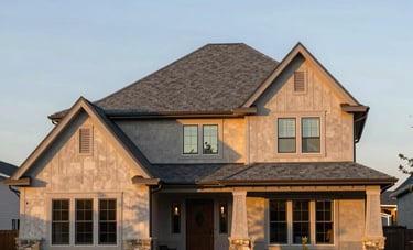 A wide shot of a beautiful North American residential house with a brand-new slate gray roof. The architecture is modern, and the lighting is the warm glow of late afternoon, emphasizing quality and curb appeal.