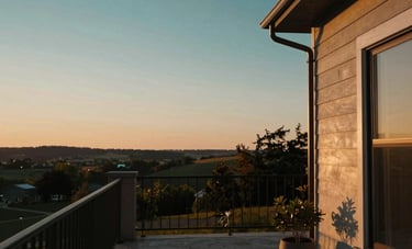 A tranquil view of a modern North American / US residence patio at sunset, representing long-term financial freedom. The lighting is warm gold and deep teal, suggesting a sophisticated and secure lifestyle.