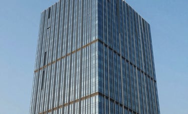 Architectural photography of a contemporary glass office skyscraper in Cyber City, Gurugram, South Asian / Indian urban business district, clear blue sky reflected in the facade, sharp lines and sleek professional aesthetic.