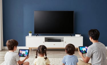 A vibrant lifestyle photograph of a family in a contemporary US home using tablets, a console, and a smart TV simultaneously without lag. The composition is wide and bright with dark blue and white tones.