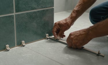 Close-up of a skilled Brazilian worker installing large porcelain tiles in a modern bathroom. Detail on the tile spacers and the precision of the layout. Soft lighting, clean environment, dark sea green and ash gray color palette.